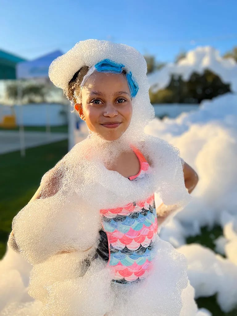 A kid covered in bubbly foam at a foam party in South Jersey