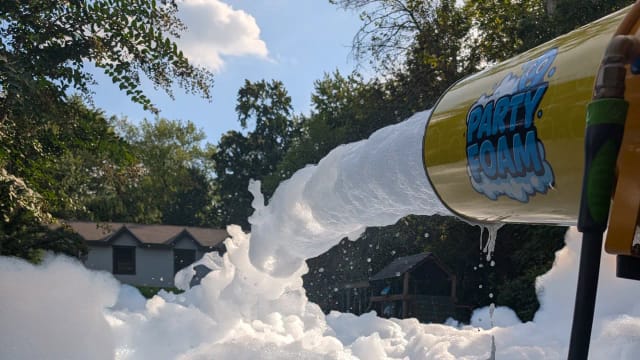 Party Foam cannon blasting foam into a backyard foam pit on a sunny day in South Jersey NJ