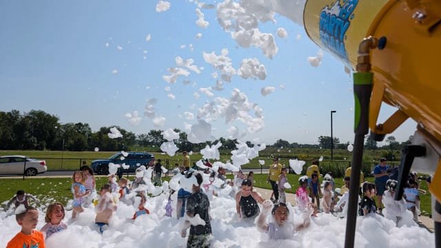kids playing in foam under a bright blue sky at an outdoor summer party in Cherry Hill NJ